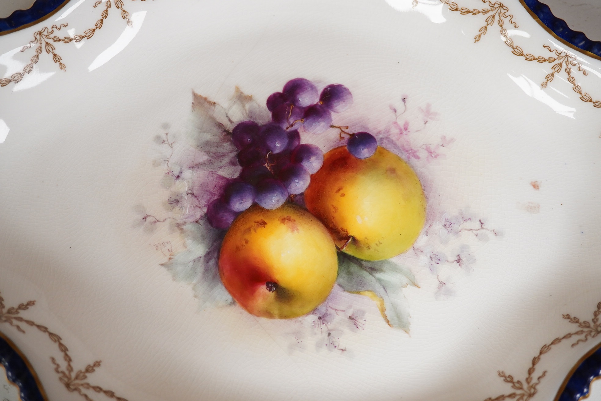 A Royal Worcester fruit painted oval dessert dish, signed Cole. 30.5cm wide. Condition - crack to base